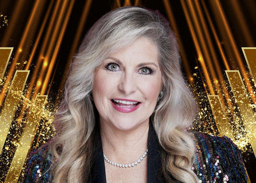 A smiling blonde woman with wavy hair wears a sparkling dark sequined top and a pearl necklace, set against a gold and black graphic background with the text 'GET CELEBRITIZED W/AUREA MCGARRY'.